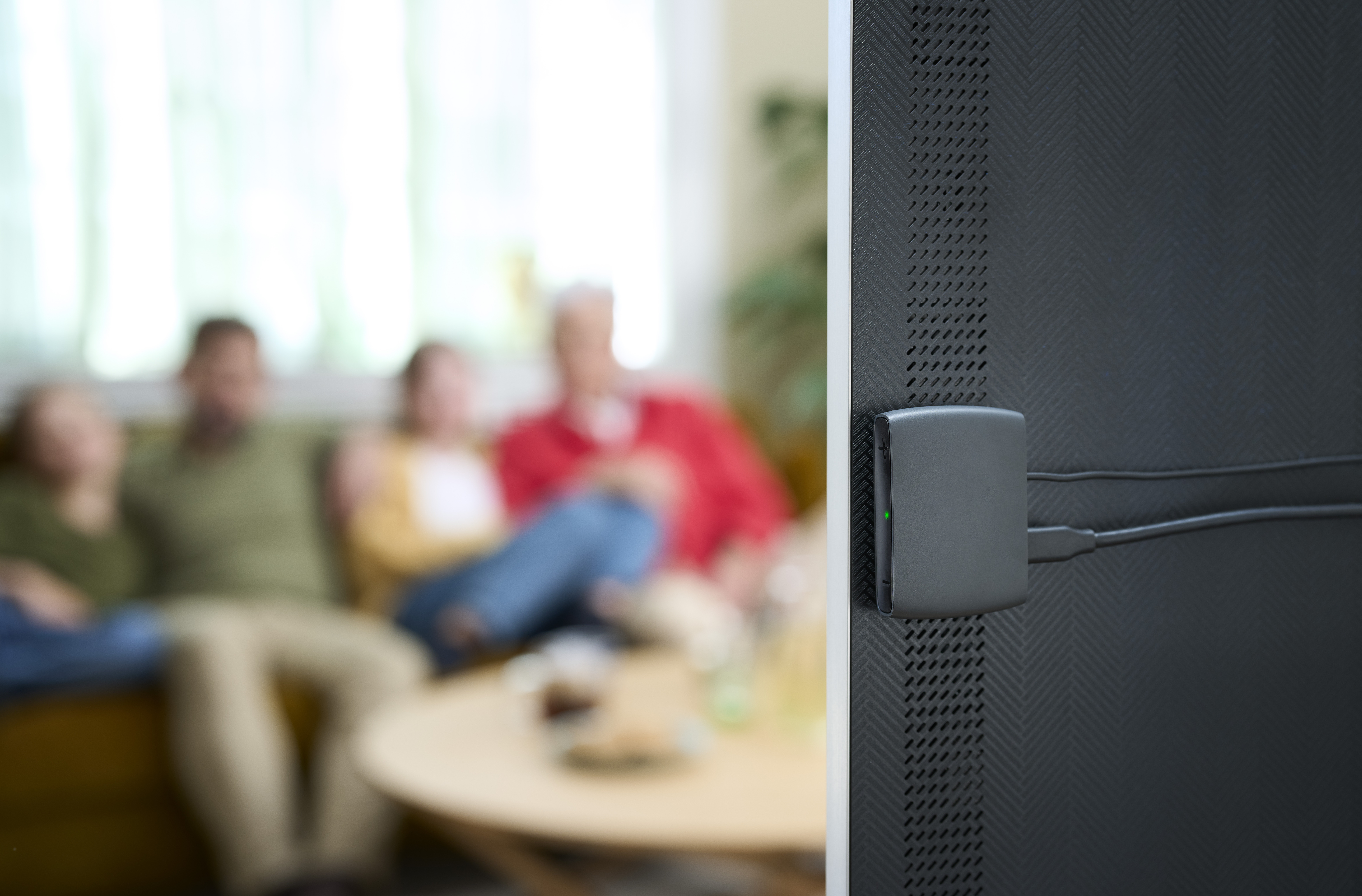 A woman arranges flowers in a vase while wearing hearing aids